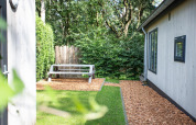Udendørs område ved Boslodge på De Thijmse Berg i Holland med bænk, træflis og grøn beplantning.