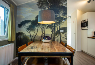 Comedor en Boslodge, De Thijmse Berg, Países Bajos, con mural de árboles, mesa de madera y decoración moderna.