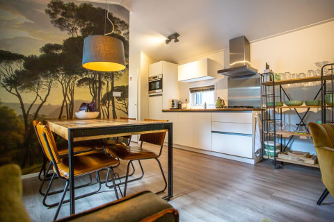 Cocina y comedor modernos en Boslodge, De Thijmse Berg, Países Bajos, con mural de bosque escénico.