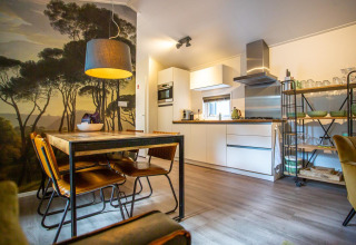 Cucina e sala da pranzo moderne a Boslodge, De Thijmse Berg, Paesi Bassi, con murale boschivo scenico.