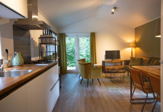 Accogliente soggiorno e cucina nella Boslodge a De Thijmse Berg, Paesi Bassi, con arredo moderno.
