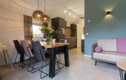 Modernes Wohnzimmer und Essbereich in der Vechtdallodge, Kampeerdorp de Zandstuve, mit offener Küche.