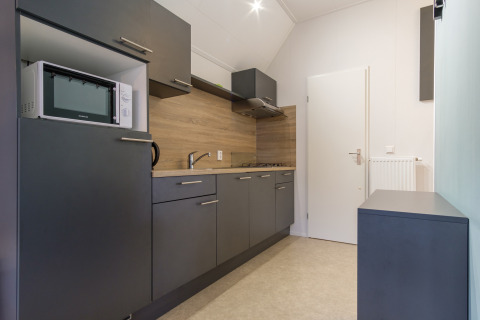 Moderne Küchenzeile in einer Vechtdallodge, Kampeerdorp de Zandstuve, Niederlande, mit grauen Schränken.