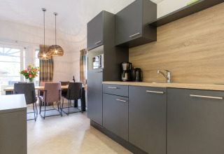 Moderne køkken og spisestue i Vechtdallodge på Kampeerdorp de Zandstuve, Holland, med stilfuldt interiør.
