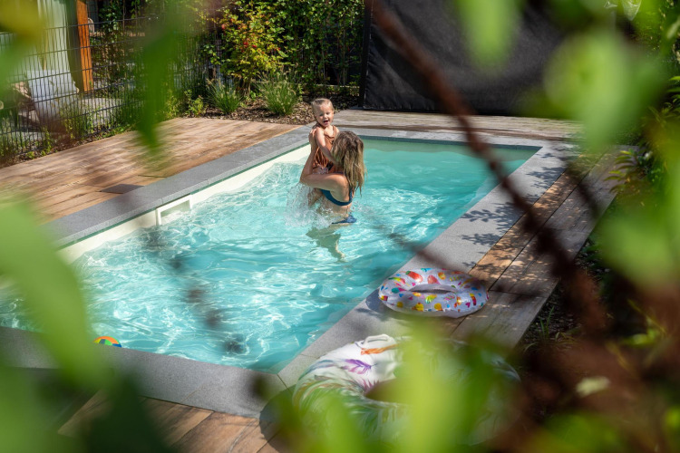 Dos personas se divierten en una piscina privada al aire libre rodeada de terraza de madera en De Thijmse Berg, Países Bajos.