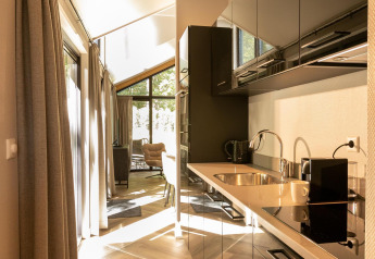 Cucina moderna al Pool Lodge di De Thijmse Berg, Paesi Bassi, con arredi eleganti e luce naturale.