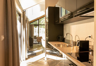 Moderne keuken in Pool Lodge aan De Thijmse Berg, Nederland, met stijlvol ontwerp en natuurlijk licht.