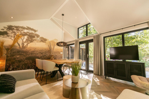 Salón moderno del Pool Lodge en De Thijmse Berg, Países Bajos, con mural natural y grandes ventanales.