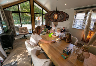 Gezin speelt gezellig een spel aan tafel in de Pool Lodge op De Thijmse Berg, Nederland.