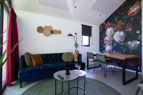 Salón moderno en Eco Cottage Comfort, De Thijmse Berg, Países Bajos, con arte floral en la pared.