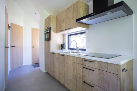 Moderne køkken i Eco Cottage Comfort på De Thijmse Berg, Holland, med træskabe og store vinduer.