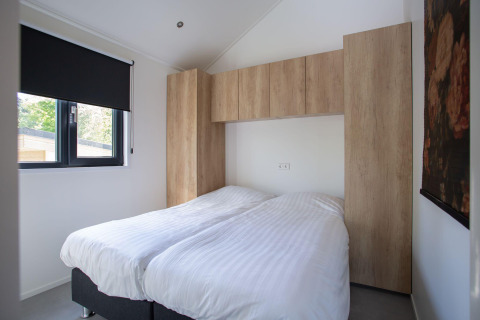 Dormitorio en Eco Cottage Comfort, De Thijmse Berg, Países Bajos, con dos camas individuales y muebles modernos.