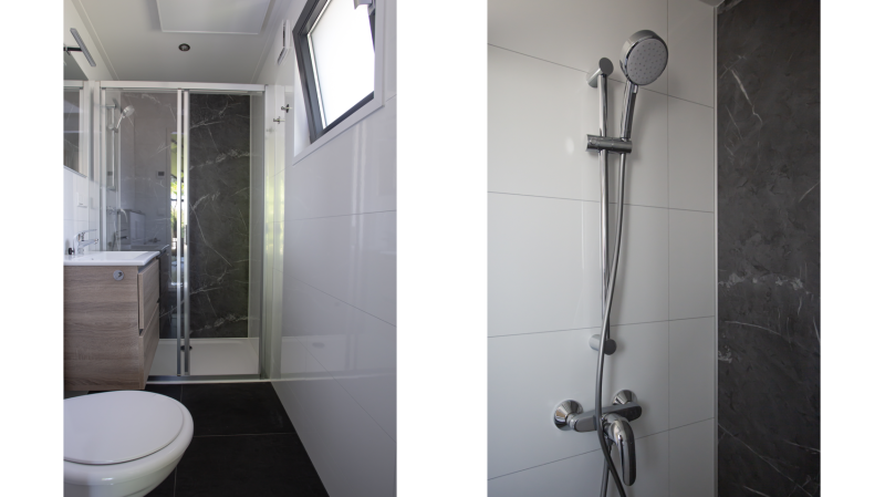 Baño moderno con ducha de vidrio, inodoro y ventana en Eco Cottage Comfort, De Thijmse Berg, Países Bajos.