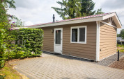 Udendørsbillede af Heuvelrug Cottage Comfort lodge ved De Thijmse Berg i Nederlandene, omgivet af grønne planter.