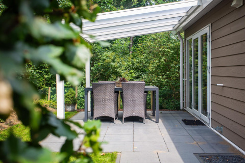 Terraza del Heuvelrug Cottage Comfort en De Thijmse Berg, Países Bajos, con mesa exterior y pérgola blanca.