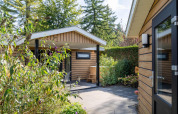 Außenbereich der Family Lodge + Hot Tub bei De Thijmse Berg in den Niederlanden mit viel Grün.