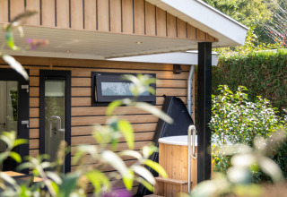 Buitenzicht op Family Lodge met houten bekleding en privé hottub op De Thijmse Berg in Nederland.
