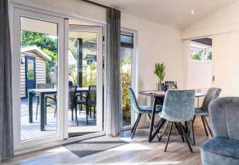 Interieur van Family Lodge bij De Thijmse Berg met eettafel, openslaande deuren en buitenzitje.