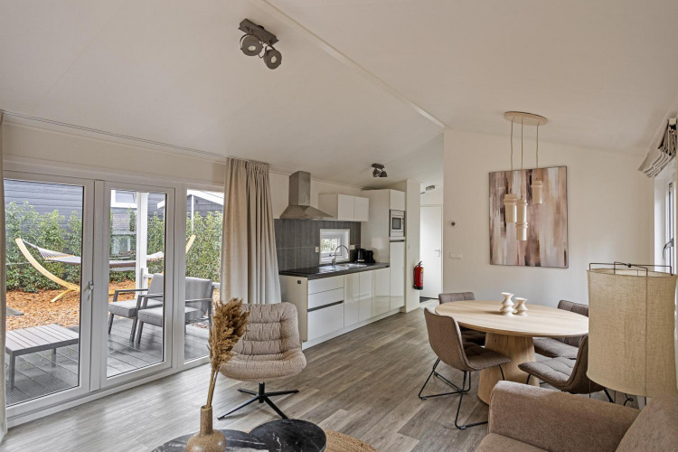 Sala de estar moderna de la Wellness Lodge en De Thijmse Berg, Países Bajos, con cocina y vista al jardín.