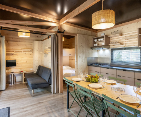 Interieur van Mobile home Columbia bij Camping de Paris in Frankrijk met eethoek, keuken en zithoek.