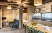 Interior of Mobile home Columbia at Camping de Paris in France showcasing dining area, kitchen and lounge.