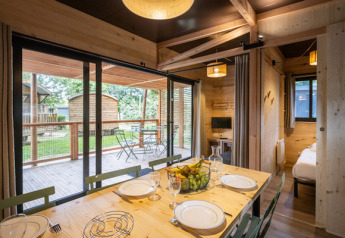 Mobil-home Columbia au Camping de Paris avec table à manger, cuisine et terrasse donnant sur le jardin