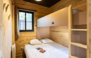 Schlafzimmer mit Doppelbett und Etagenbett im Mobile Home Columbia, Camping de Paris, Frankreich.