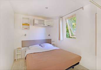 Moderne, minimalistisk mobilhytte Cottage på Camping de Strasbourg med dobbeltseng og åben vindue.