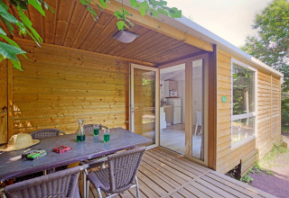 Houten mobile home cottage met overdekt terras bij Camping de Strasbourg in Frankrijk.