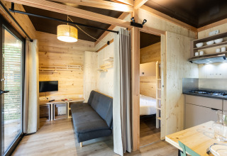 Vista interior del Chalet Columbia en Camping de l'Ill - Colmar en Francia, con decoración de madera moderna.