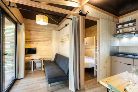 Vista interior del Chalet Columbia en Camping de l'Ill - Colmar en Francia, con decoración de madera moderna.
