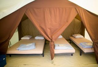 Binnenzicht van een Bungalow tent CLASSIC IV met vier eenpersoonsbedden bij Huttopia Lac d’Aiguebelette, Frankrijk.