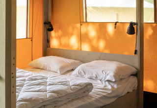 Innenansicht eines Safari-Zeltes mit Doppelbett auf Camping Si-Es-An in den Niederlanden, Tageslicht.