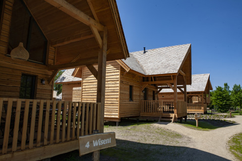 Houten huisjes bij Sandberghe in Nederland op een zonnige dag, met het tiny house Heydehuis links in beeld.