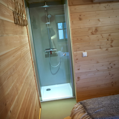 Moderne douche in een knus, hout bekleed tiny house bij Heydehuis op Sandberghe in Nederland, compact ontwerp.