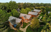 Vue aérienne des lodges Heydehuis + Jacuzzi à Sandberghe aux Pays-Bas, entourés d’arbres verts.