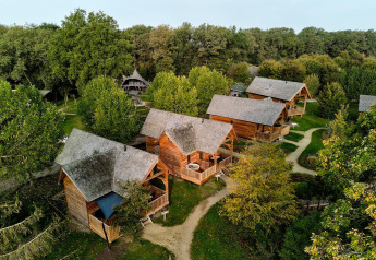Aerial view of Heydehuis + Jacuzzi lodges at Sandberghe in the Netherlands, surrounded by trees.