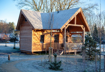 A cozy wooden lodge with a porch on a frosty morning at Heydehuis + Jacuzzi in Sandberghe, Netherlands.