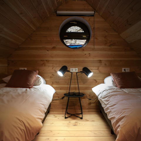 Dormitorio acogedor en Heydehuis + Jacuzzi en Sandberghe, Países Bajos, con dos camas y lámparas modernas.