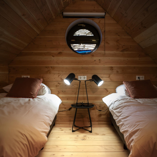 Dormitorio acogedor en Heydehuis + Jacuzzi en Sandberghe, Países Bajos, con dos camas y lámparas modernas.