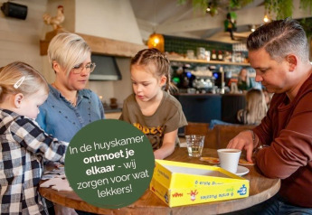 Familie hygger sig med et puslespil i fællesrummet på glamping-stedet Heydehuis + Jacuzzi.