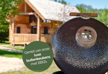 Luxury outdoor kitchen with BBQ at Heydehuis + Jacuzzi glamping, wooden cabin in background, summer vibe.