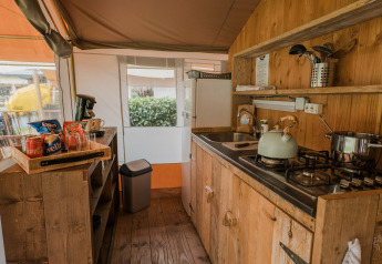 Área de cocina en una Lodgetent Beaufort en Beter Uit Holiday Park Walsdorf, Luxemburgo, con interior de madera.