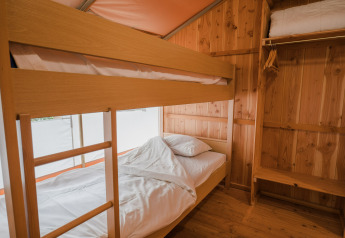 Interior de la tienda safari Lodgetent Beaufort en Beter Uit Holiday Park Walsdorf, Luxemburgo, con literas visibles.