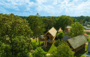 Aerial view of Heydehuis + Jacuzzi treehouse at Sandberghe in the Netherlands, surrounded by lush greenery.