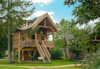 Heydehuis + Jacuzzi tree house at Sandberghe in the Netherlands, featuring a wooden deck and stairs.