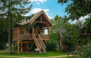 Baumhaus Heydehuis + Jacuzzi bei Sandberghe in den Niederlanden, umgeben von Bäumen und Natur.