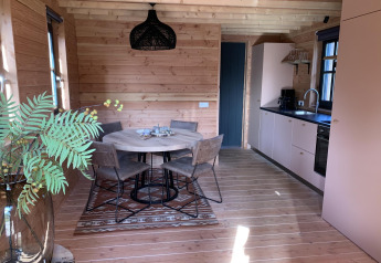 Moderne træhytte med spisebord, køkken og store vinduer i Heydehuis + Jacuzzi, Sandberghe, Holland.