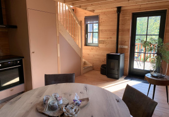 Modern treehouse interior at Heydehuis + Jacuzzi, Sandberghe, Netherlands, with wooden stairs and cozy decor.