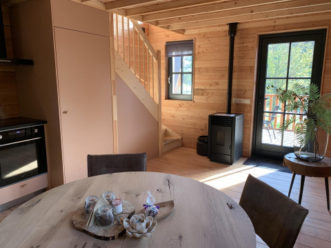 Gezellig boomhuisinterieur in Heydehuis + Jacuzzi, Sandberghe, Nederland, met houten trap en ronde tafel.